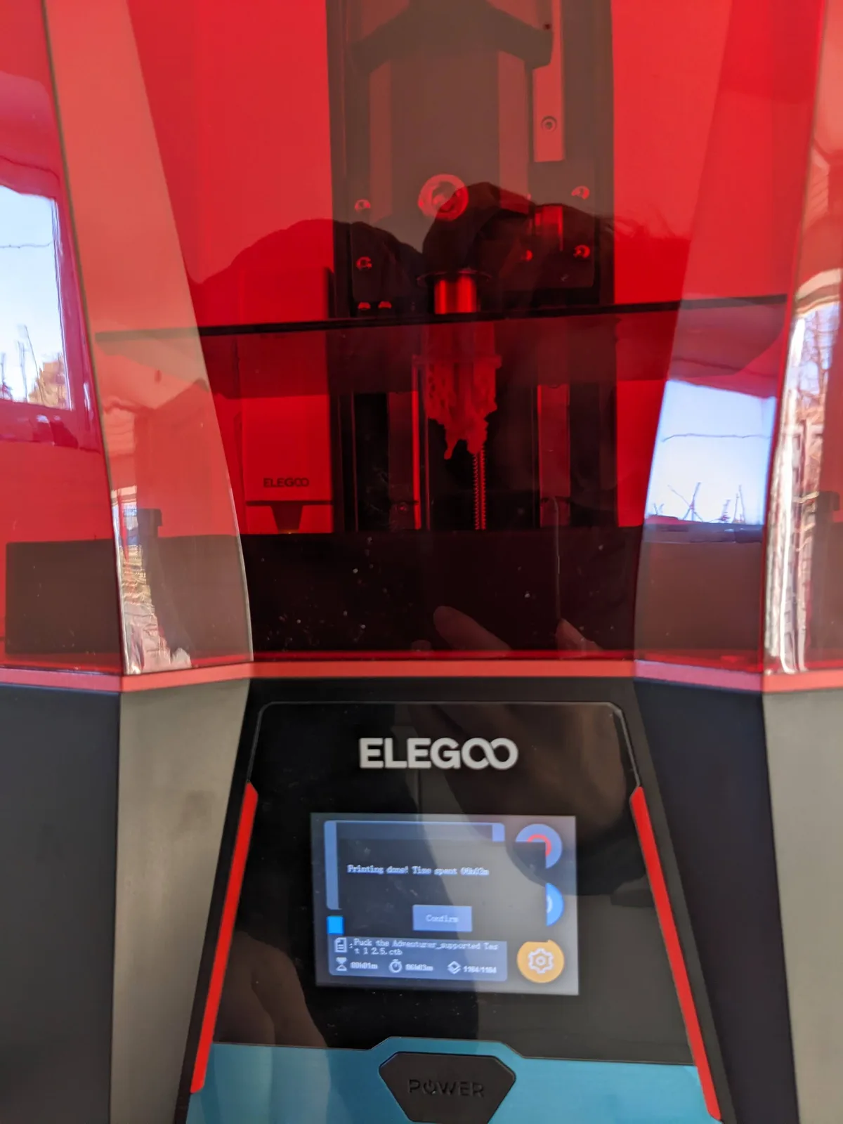 Elegoo Saturn 2 front hero view, lid on, red acrylic cover, ELEGOO logo, touchscreen reading Printing done with a 09h46m time spent and a Confirm button