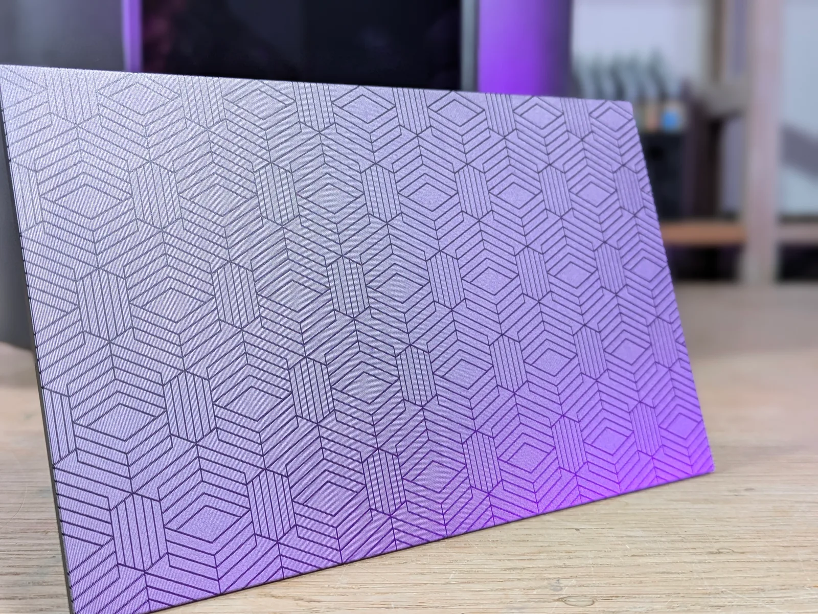 Elegoo Mars 4 Ultra build plate lifted off the printer and propped on the bench, showing the laser etched hex cube pattern