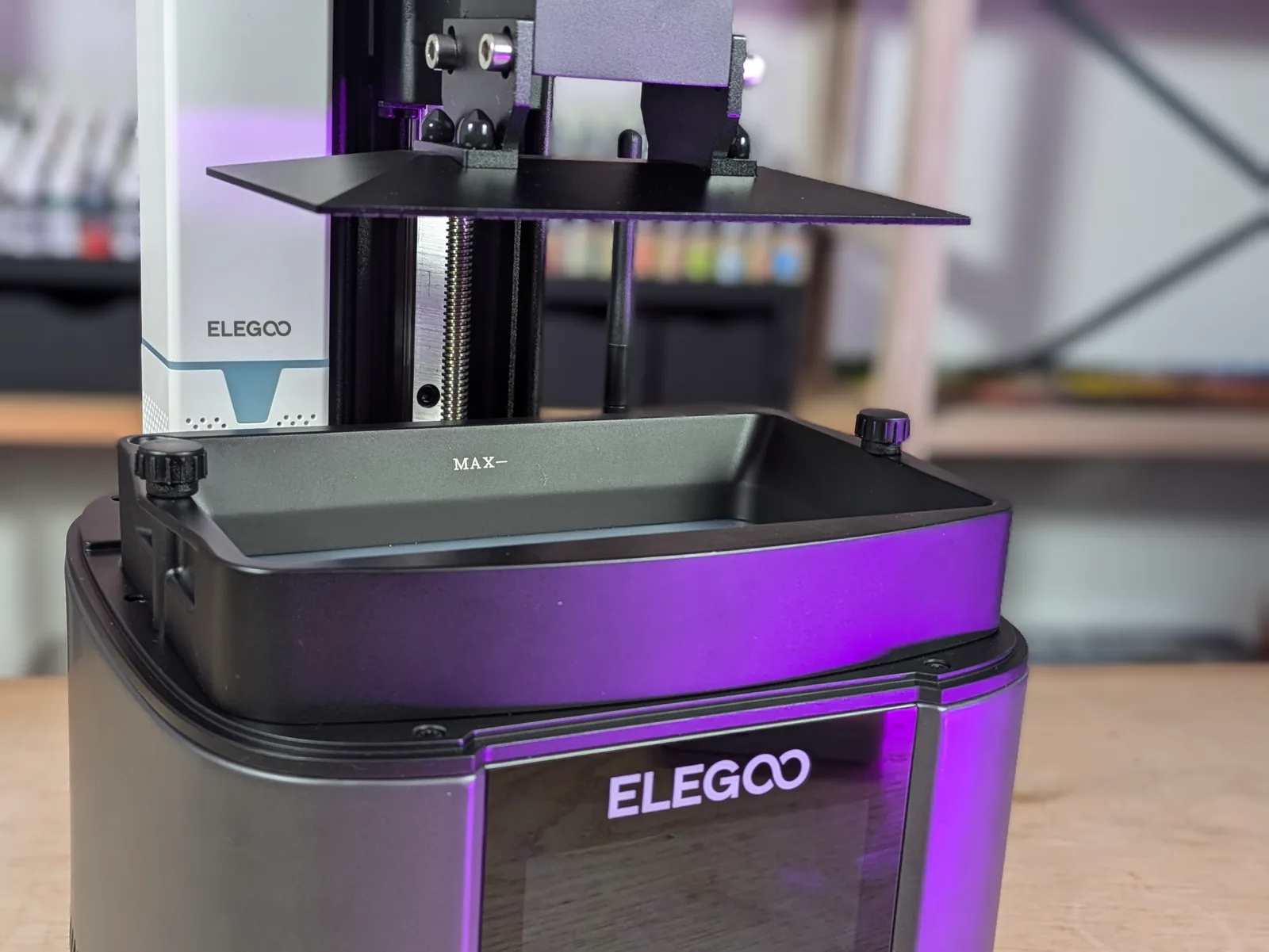 Mars 4 Ultra with lid off showing black build plate raised above empty resin vat, Z-axis lead screw visible, MAX branded vat in position below, anatomy shot showing the relationship between build plate and FEP