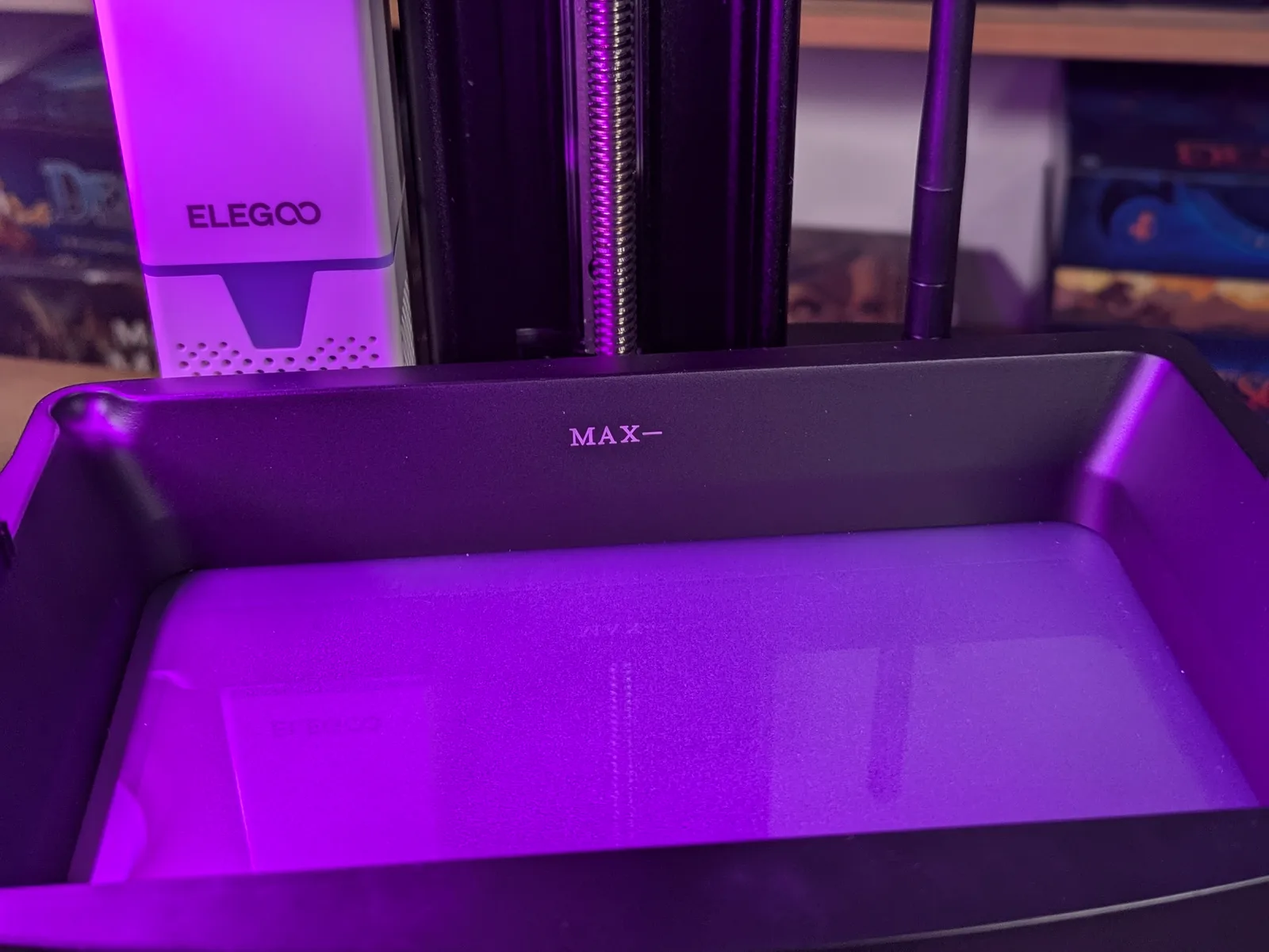 Top down view into the empty Elegoo Mars 4 Ultra resin vat with the taut FEP film catching purple LED light and the MAX fill line visible on the rim