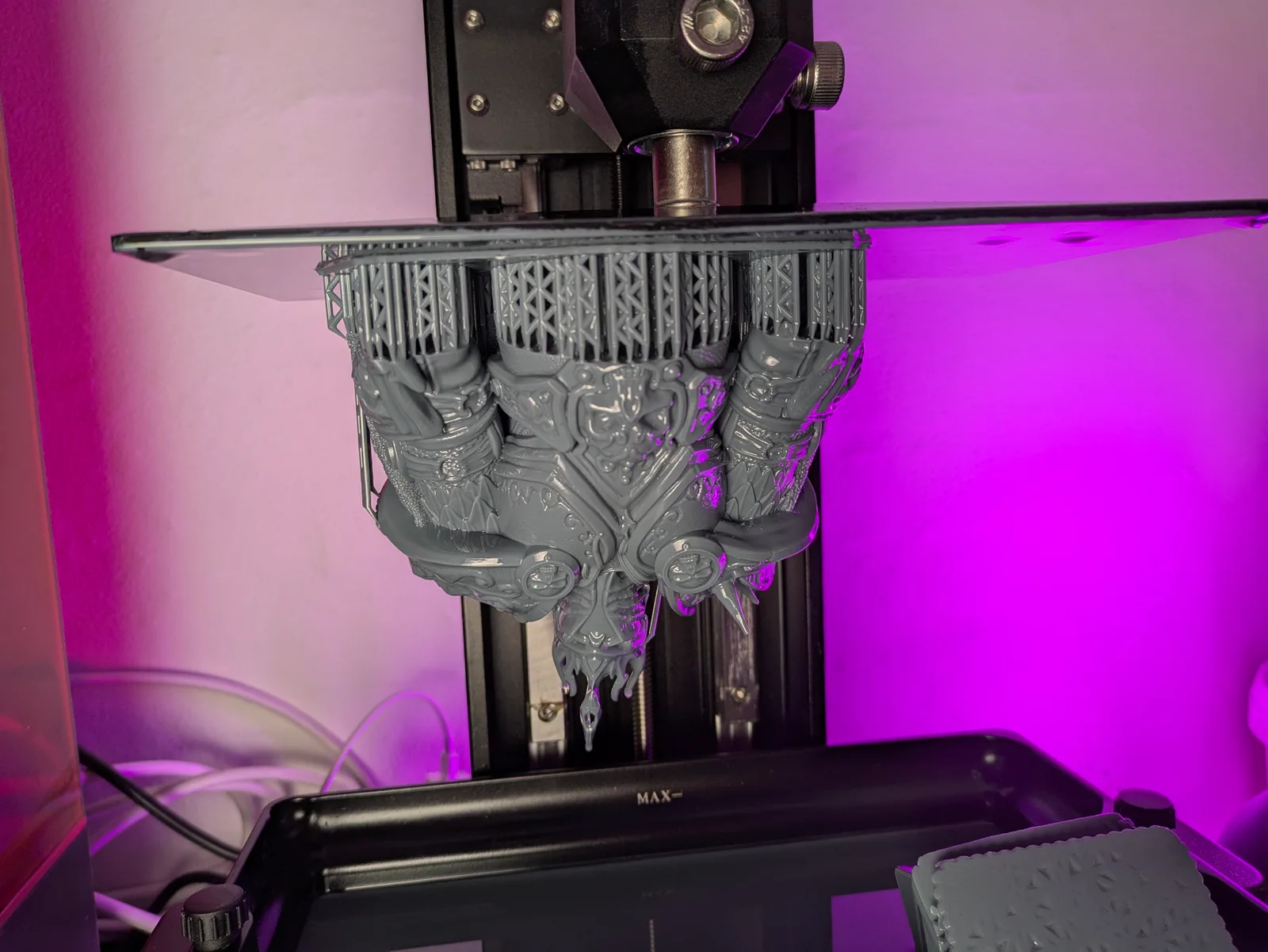Saturn 4 Ultra build plate lifted mid-print, large detailed throne group sculpt hanging from the plate above the open vat, dual Z-axis rails visible