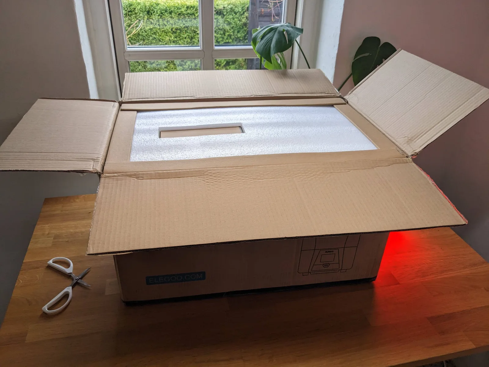 Elegoo Saturn 2 shipping box opened showing the printer surrounded by foam inserts, ready for long-term storage